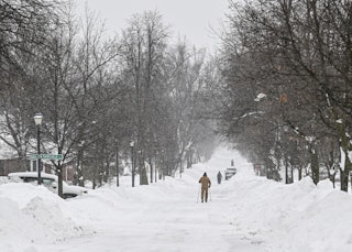 NEW YORK, UNITED STATES - DECEMBER 26: A man walks on the snow covered sidewalk after snowfall in Bu...