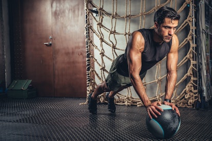 Handsome man exercising plank pose on a medicine ball