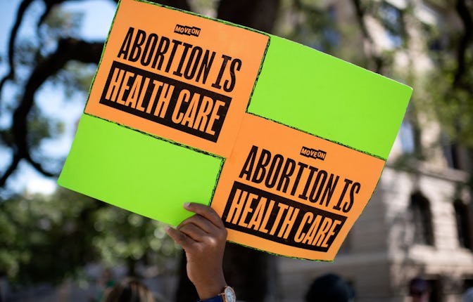 An abortion rights demonstrator holds a sign outside of the Harris County Courthouse during the Wome...