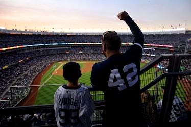 NEW YORK, NY - OCTOBER 22:  A father and son are seen cheering during Game 3 of the ALCS between the...