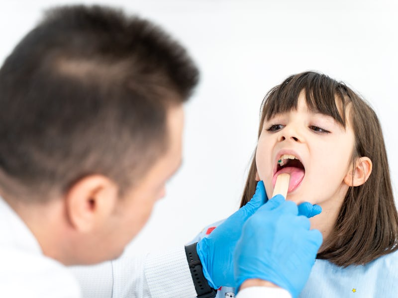 child patient opening her mouth for the doctor to look in her throat. strep a