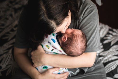 Baby boy of 15 days old in mother's arms in a list of baby boy names that start with N