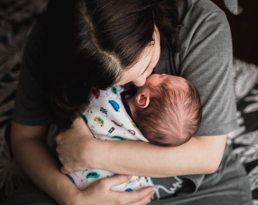 Baby boy of 15 days old in mother's arms in a list of baby boy names that start with N