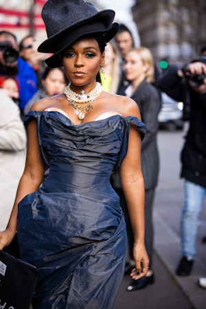 Janelle Monae, wearing a grey dress, black and grey double hat and pearl necklaces, is seen outside ...