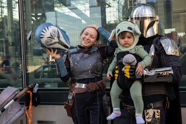 NEW YORK, NEW YORK - OCTOBER 07: A family dressed as Star Wars' Mandalorian and Baby Yoda (Grogu) po...