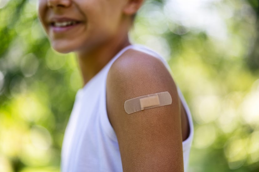 kid with a bandaid after getting a seasonal flu shot in an article about flu shot myths and if you'r...