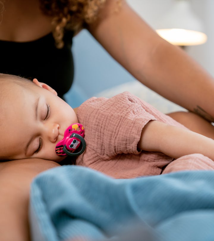 A mom pats her baby to sleep instead of using a plush fish that pats baby to sleep.