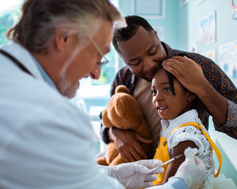 Close up of a little girl getting vaccinated by her pediatrician in an article about flu shot side e...