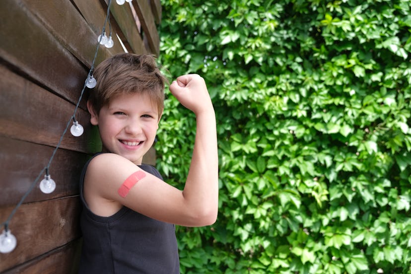 child with vaccine bandaid in an article about are you contagious after flu shot