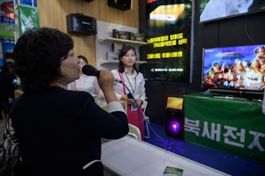 A woman sings into a karaoke machine at a booth of the North Korean Puksae Electronic Technology Com...