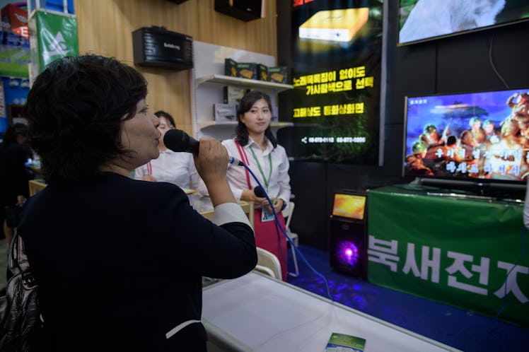 A woman sings into a karaoke machine at a booth of the North Korean Puksae Electronic Technology Com...