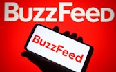 UKRAINE - 2021/12/18: In this photo illustration, BuzzFeed Inc. logo is seen on a smartphone and a c...