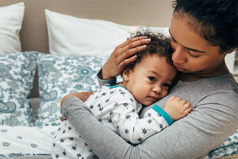 a mom comforting her kid in an article about blood in snot baby