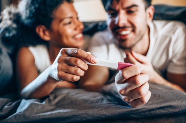 Shot of a happy young couple taking a pregnancy test at home, in an article about Sagittarius horosc...