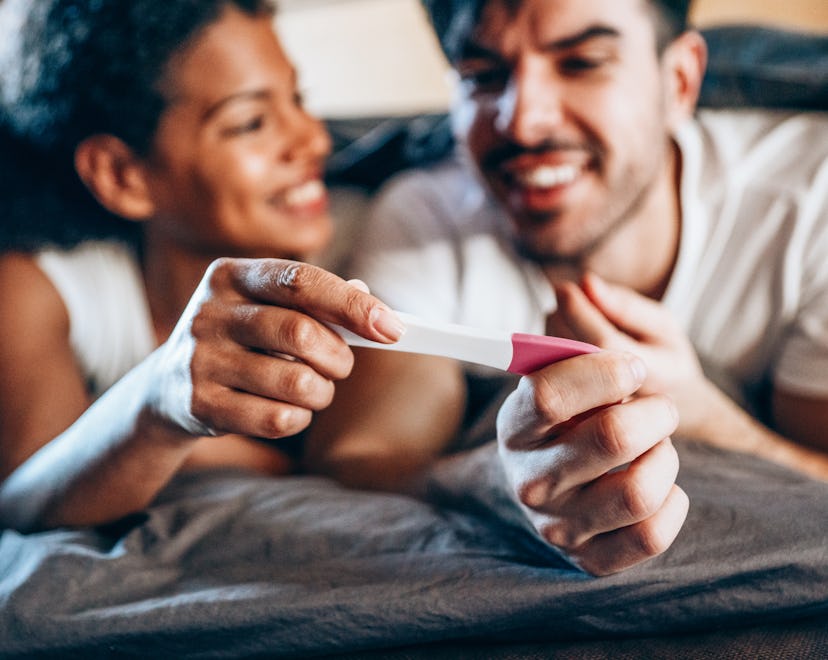 Shot of a happy young couple taking a pregnancy test at home, in an article about Sagittarius horosc...