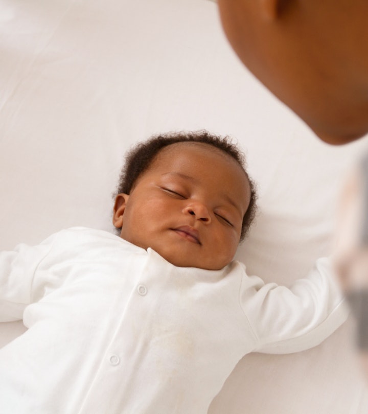 a baby sleeping in a crib in an article about the cry it out method of sleep training