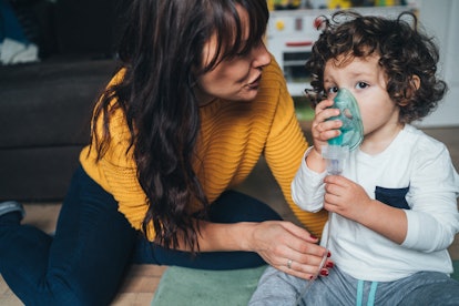 Mother helps her little boy to makes inhalation at home in an article about can you give a sleeping ...