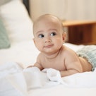 Adorable baby boy lying on stomach in bed