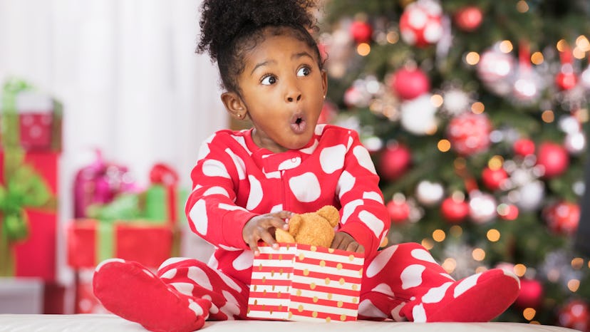 little girl opening a gift in a list of gift captions for instagram