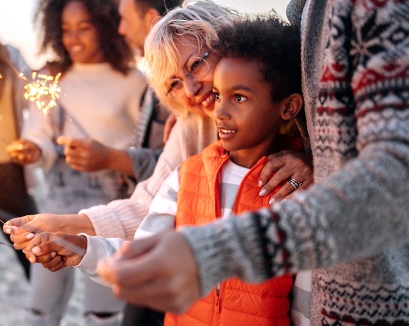 Multigenerational family with firework sparklers on the beach