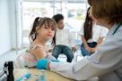 医生给亚洲小女孩的手臂注射疫苗