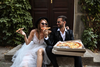 A bride and groom enjoy the 2023 wedding food trends that include relatable food. 