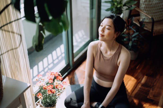 woman doing yoga at home, big exhales are in order for capricorns in 2023