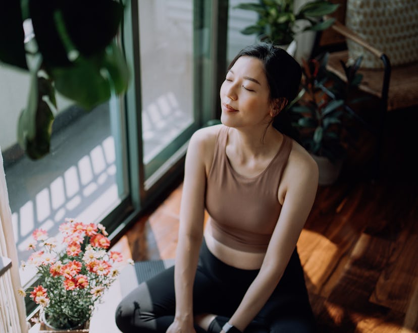 woman doing yoga at home, big exhales are in order for capricorns in 2023