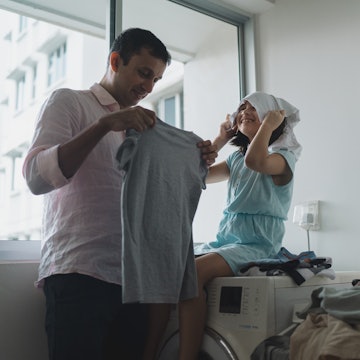 Dad and daughter folding laundry. More and more dads are opting to be the stay-at-home-parent, with ...