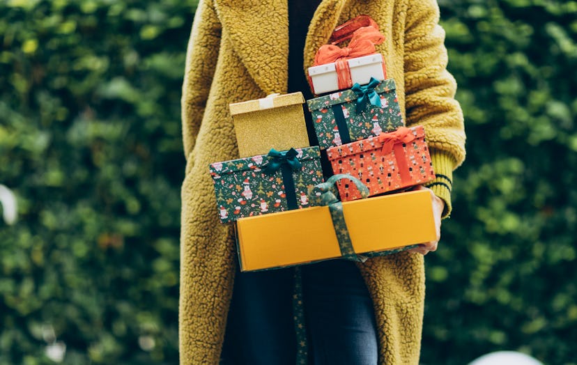 person holding a stack of gifts in a list of perfect gift captions for instagram
