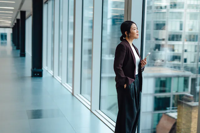 Woman in business setting looking out window, thinking about aquarius 2023 horoscope