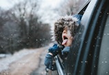 Boy on a road trip sticking his tongue out the window to catch snowflakes, in a story about tips for...