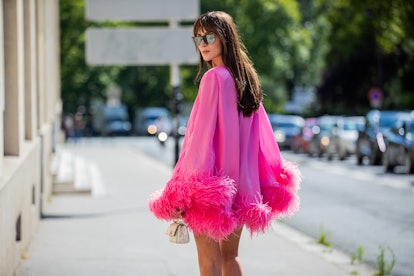 A model wears a Barbiecore dress that's hot pink, and channeling the "more is more" wedding trend of...