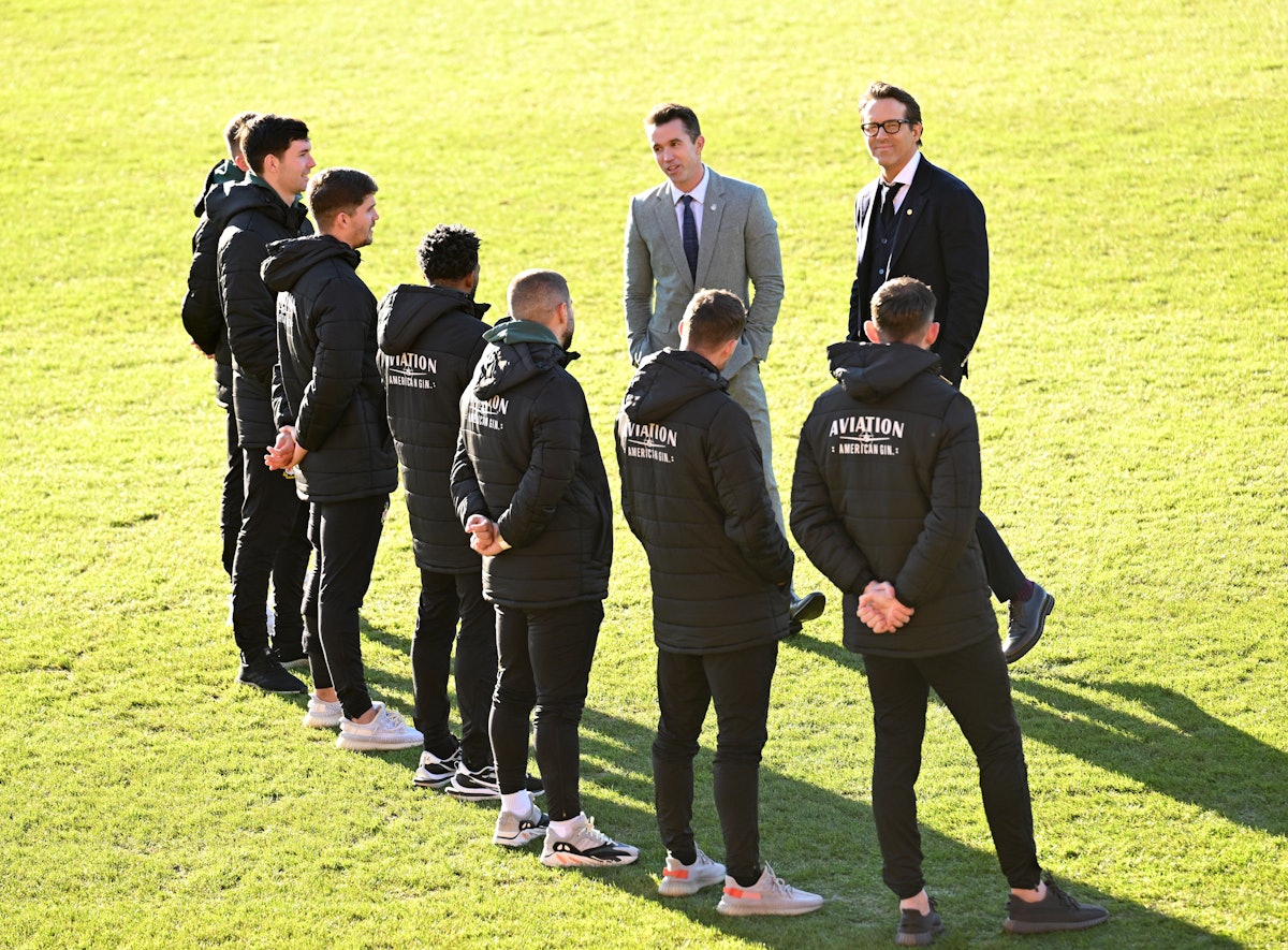 WREXHAM, WALES - DECEMBER 09: Co-Owners of Wrexham AFC Rob McElhenney and Ryan Reynolds talk to play...