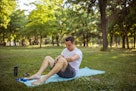 一名年轻男子在公园里的瑜伽垫上练习