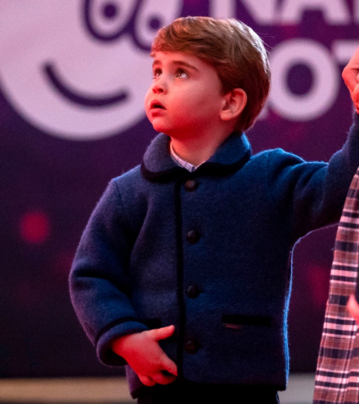 Britain's Prince Louis of Cambridge holds his mother's hand as they attend a special pantomime perfo...