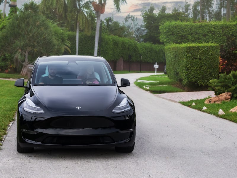 Miami, FL, United States - September 13, 2021: Tesla Model Y parked on the street with two people. T...