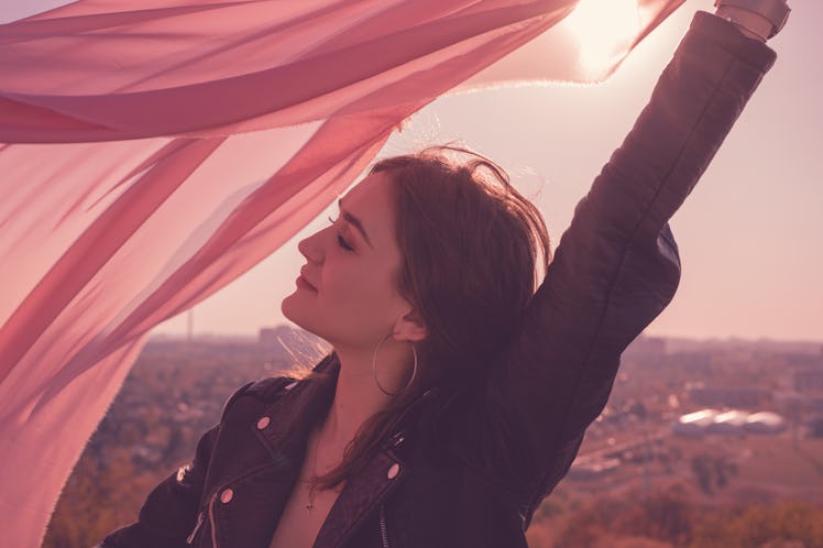 Young woman enjoying the breeze in the air, knowing her lucky zodiac sign will have the best week of...