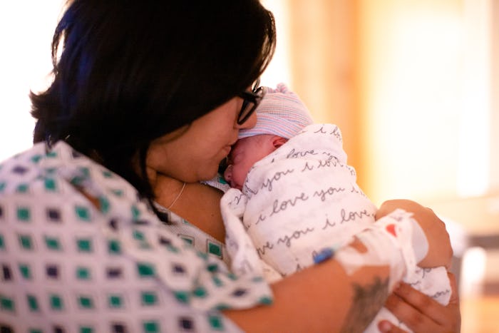 A mother holds her newborn daughter for the first time in the hospital.
