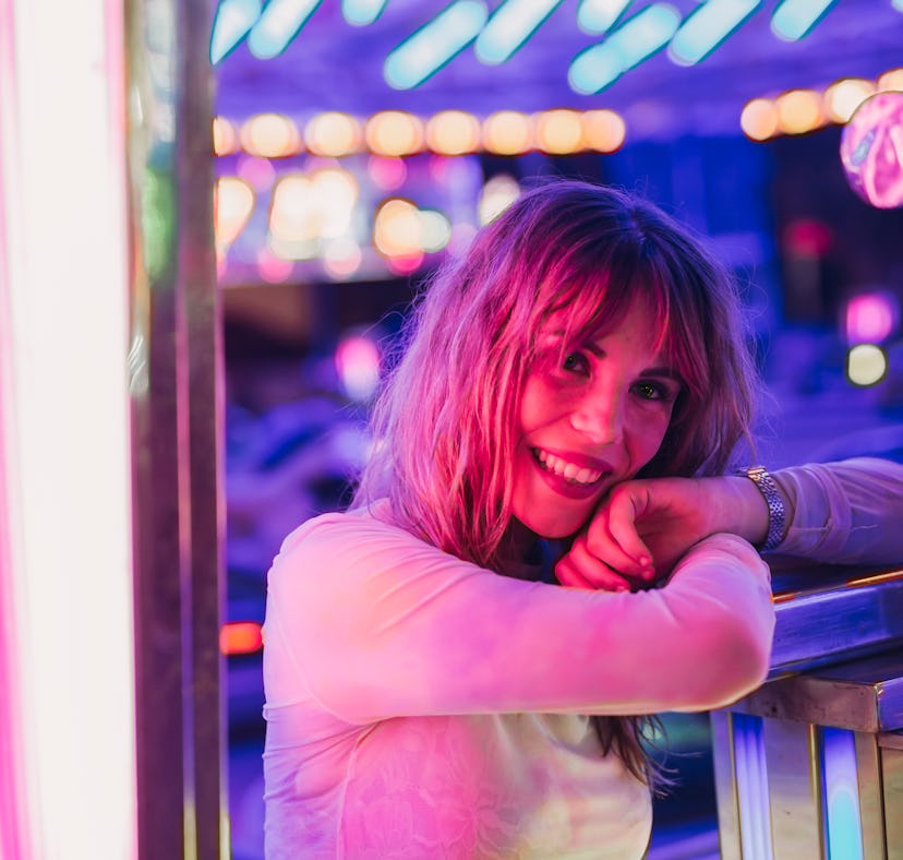 Young woman smiling at a carnival, knowing her lucky zodiac sign will have the best week of February...