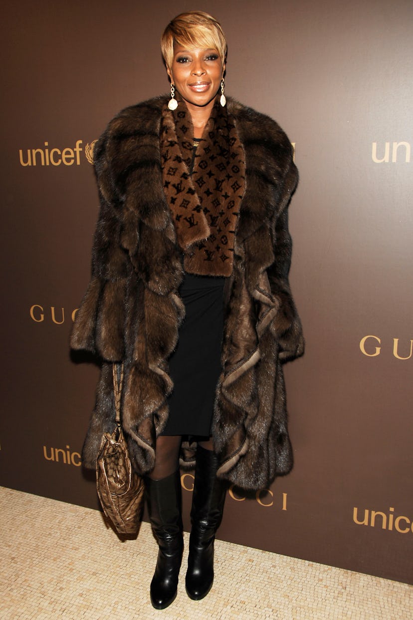 Mary J. Blige in a fur coat and scarf with black boots. 