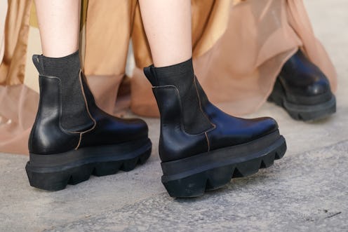 A pair of black chelsea boots with a raised, platform heel.
