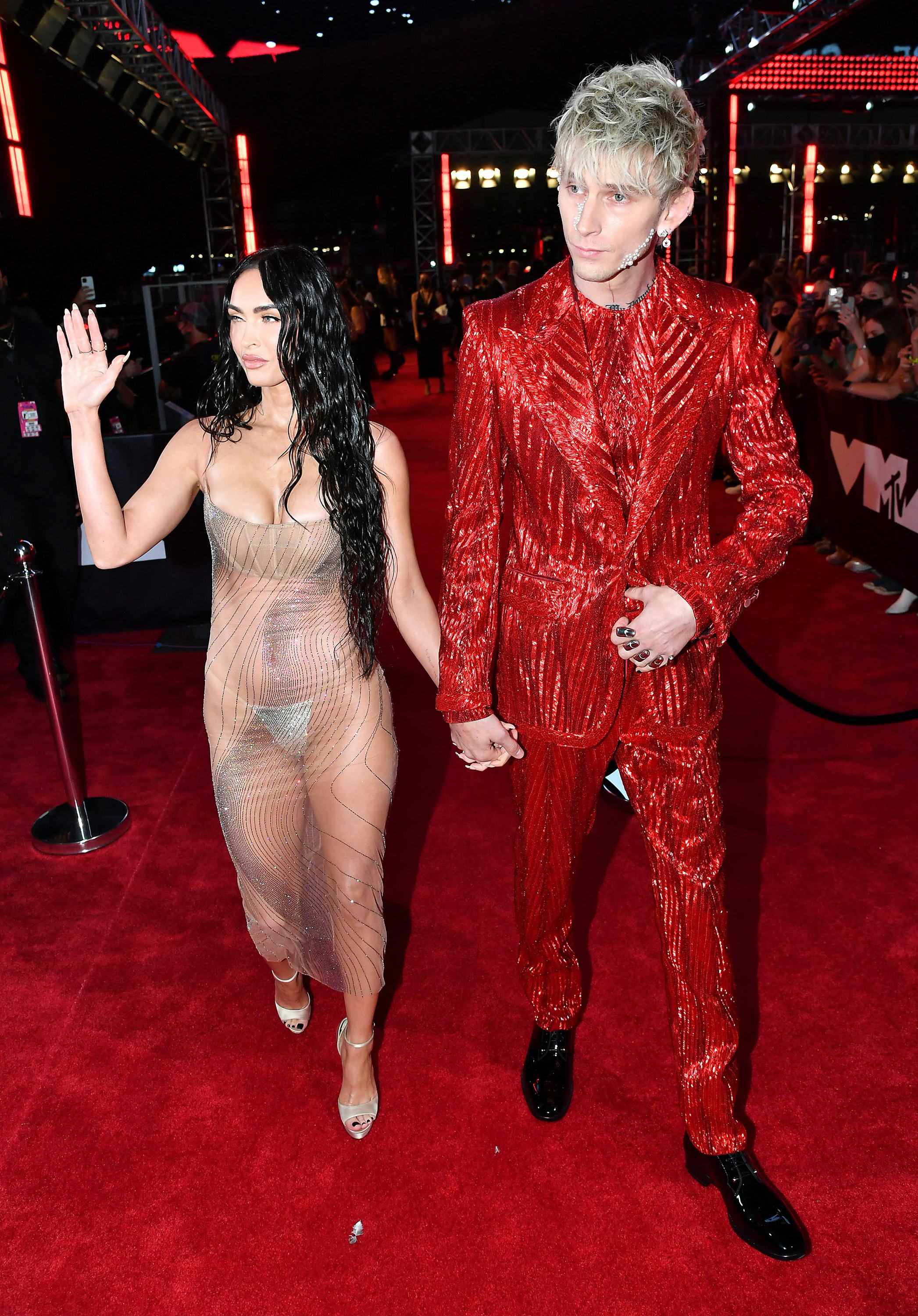 Megan Fox in a sheer gown and Machine Gun Kelly in a red, sparkly suit.