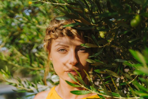 Portrait of a woman behind plants. Taurus, Leo, Scorpio, and Aquarius will be most affected by the 2...