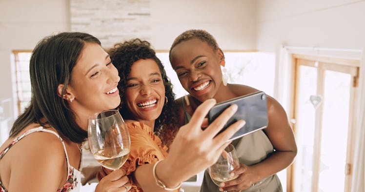 Shot of a group of young friends watching the super bowl and taking selfies, for which they'll need ...