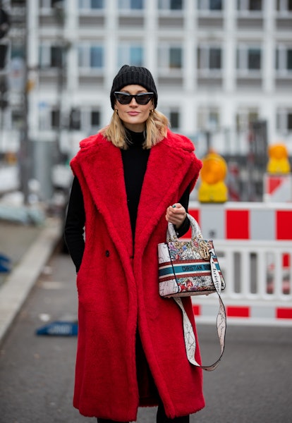 Mandy Bork wears a black beanie, red vest-coat, and a black turtleneck on December 18, 2021 in Berli...