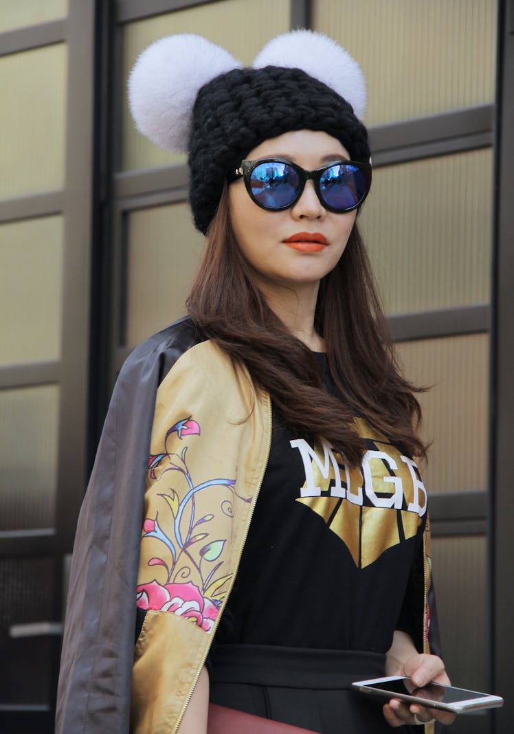 Eunice Zhang wore a gold Ed Hardy silk embroidered bomber jacket, Jiang sweater, sunglasses and blac...