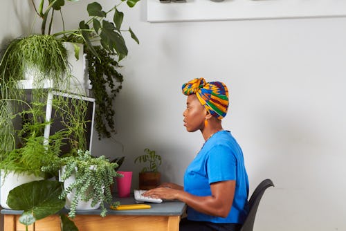 Side view point of a woman working at a desk with plants. Here's your career horoscope for the U.S.'...