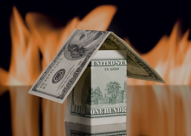 Dollar house on background of fire