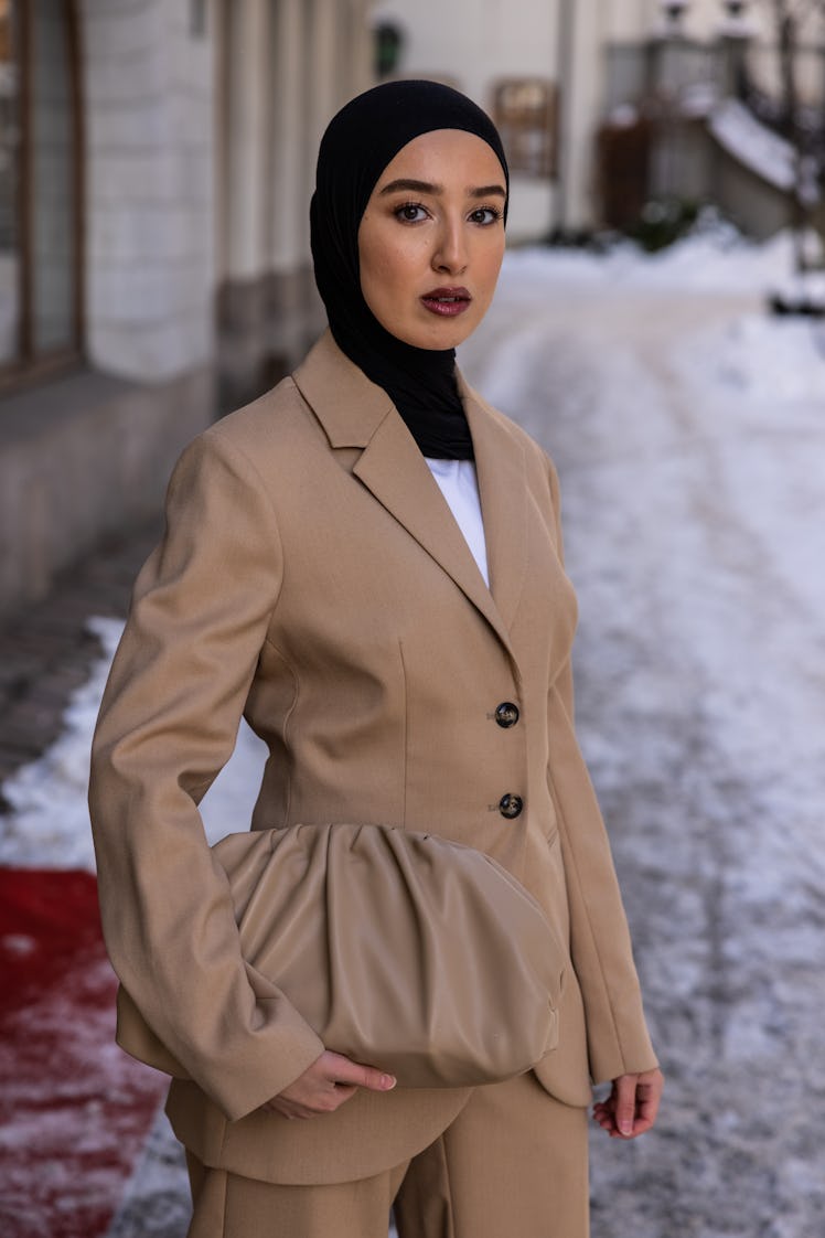 Imane Asry in a black snood and khaki suit on February 9, 2021 in Stockholm, Sweden.